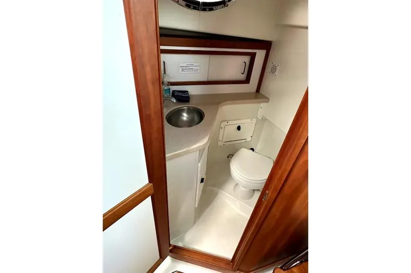 Slide: The Image of 2007 Back Cove 29 boat bathroom with sink, toilet, and wooden cabinetry. - 6
