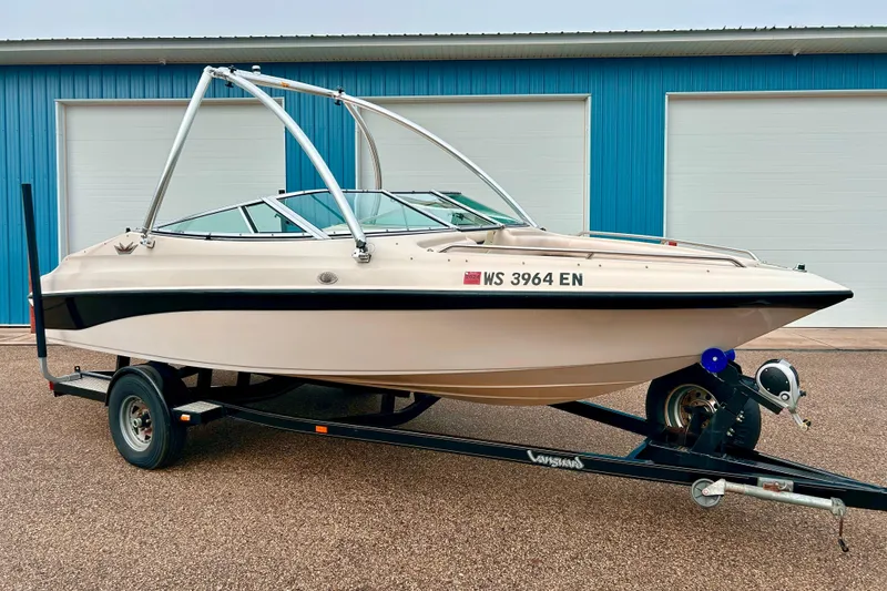The Image of 1995 Crownline 202 BR boat on trailer, parked in front of blue garage doors. - 0