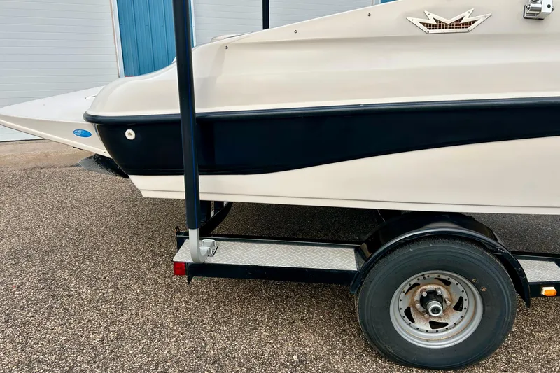 Slide: The Image of 1995 Crownline 202 BR boat on trailer, featuring sleek black and white design. - 12