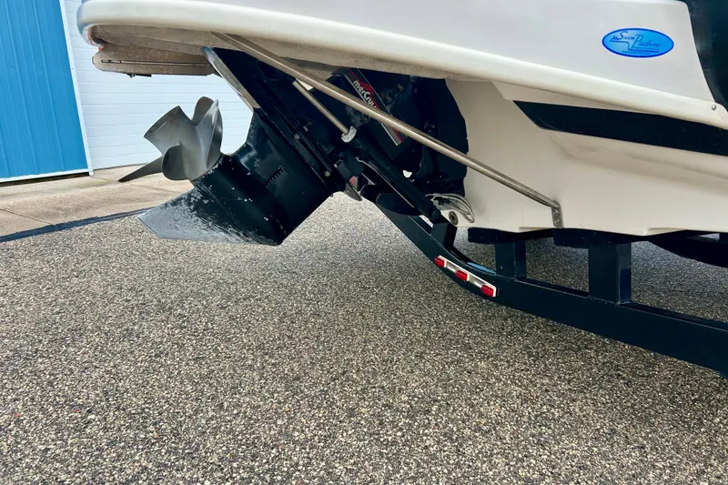 Slide: The Image of 1995 Crownline 202 BR boat stern with propeller and trailer on pavement. - 14