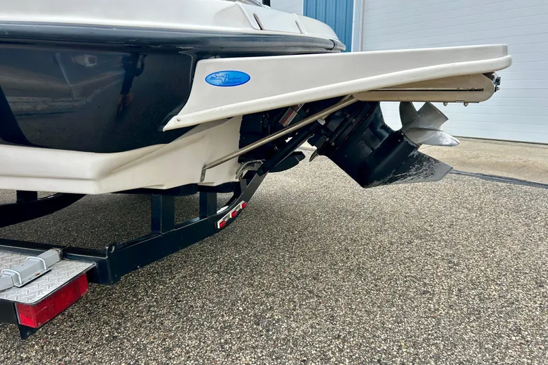 Slide: The Image of 1995 Crownline 202 BR boat stern with propeller and trailer on pavement. - 16