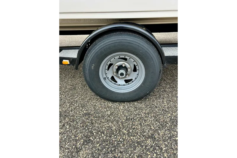 Slide: The Image of Trailer wheel of a 1995 Crownline 202 BR boat on asphalt. - 27