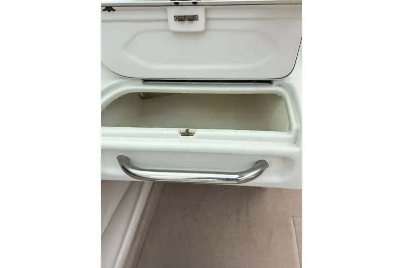 Slide: The Image of Storage compartment in a 1995 Crownline 202 BR boat, featuring a sleek metal handle. - 35