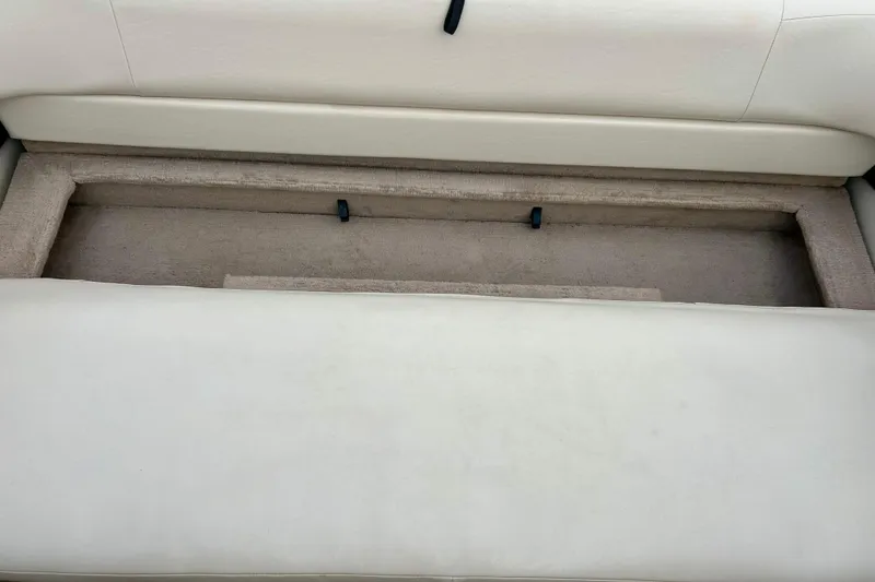 Slide: The Image of Crownline 202 BR 1995 boat interior storage compartment with beige upholstery. - 38