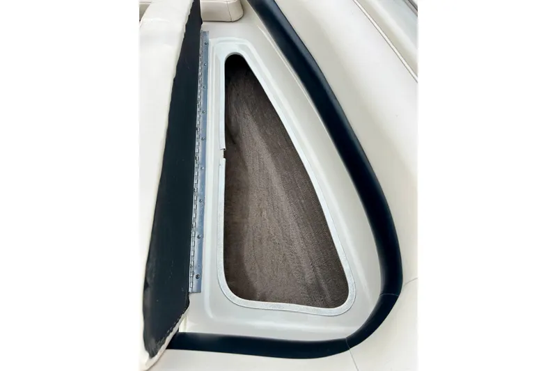 Slide: The Image of 1995 Crownline 202 BR boat storage compartment with cushioned interior and sleek design. - 43