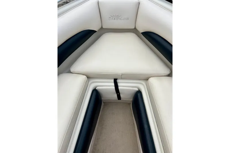 Slide: The Image of Interior seating of a 1995 Crownline 202 BR boat, featuring white and black upholstery. - 46