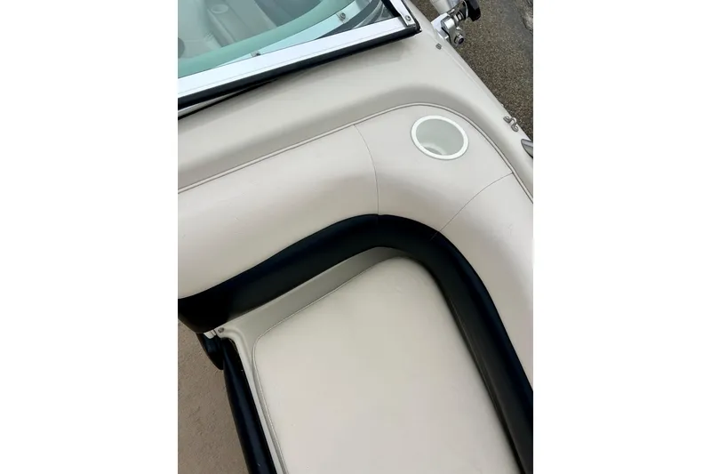 Slide: The Image of 1995 Crownline 202 BR boat interior with beige seating and cup holder. - 50