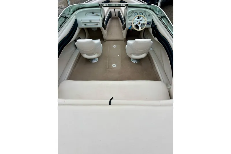 Slide: The Image of 1995 Crownline 202 BR boat interior with beige seating and dashboard. - 6