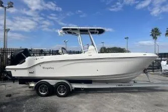 The Image of 2023 Trophy T24 CC boat on trailer, parked outdoors under blue sky. - 1