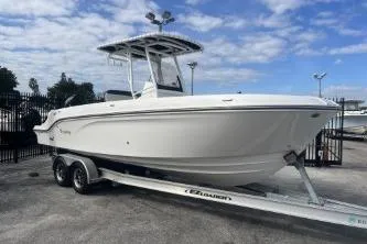 Slide: The Image of 2023 Trophy T24 CC boat on trailer under blue sky. - 2