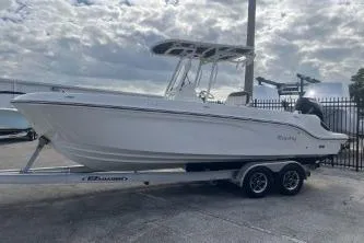 Slide: The Image of 2023 Trophy T24 CC boat on trailer, parked outdoors under cloudy sky. - 5
