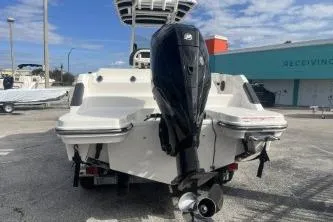 Slide: The Image of 2023 Trophy T24 CC boat with powerful outboard motor, parked outdoors under a blue sky. - 6