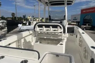 Slide: The Image of 2023 Trophy T24 CC boat interior with rod holders and seating, docked outdoors. - 7