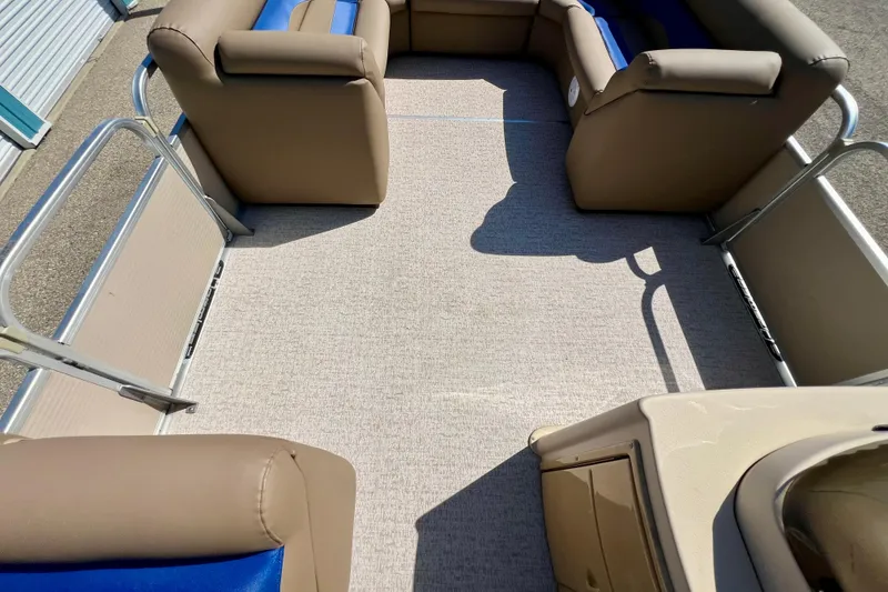 Slide: The Image of 2001 Premier 250 Grand Majestic pontoon boat interior with beige seating and blue accents. - 10