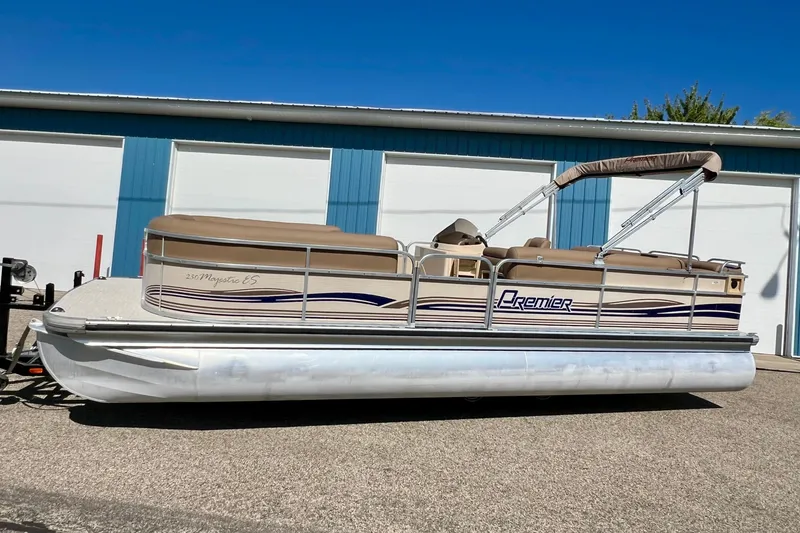 Slide: The Image of 2001 Premier 250 Grand Majestic pontoon boat parked outside blue garage. - 26