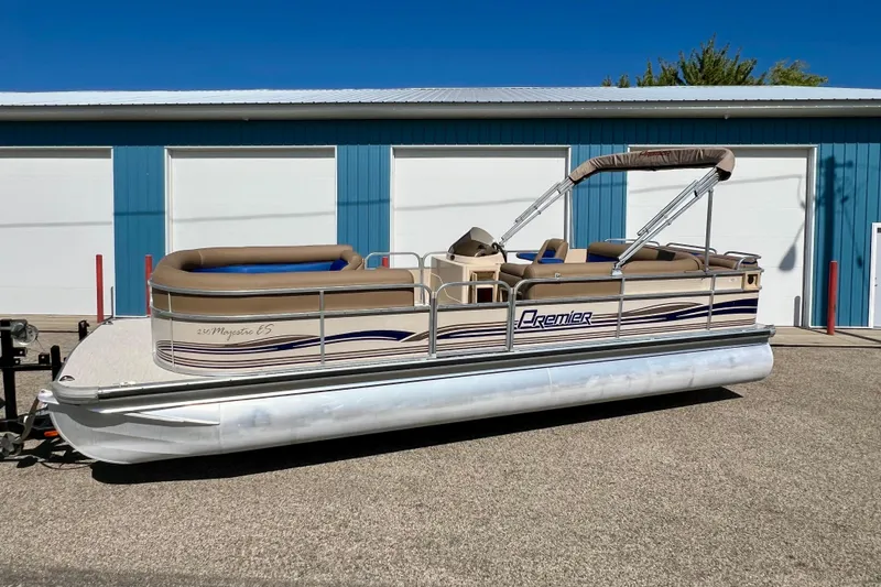 Slide: The Image of 2001 Premier 250 Grand Majestic pontoon boat parked outside a blue garage. - 28