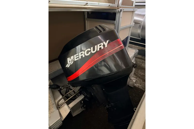 Slide: The Image of 2001 Premier 250 Grand Majestic pontoon boat parked outside a blue garage. - 29