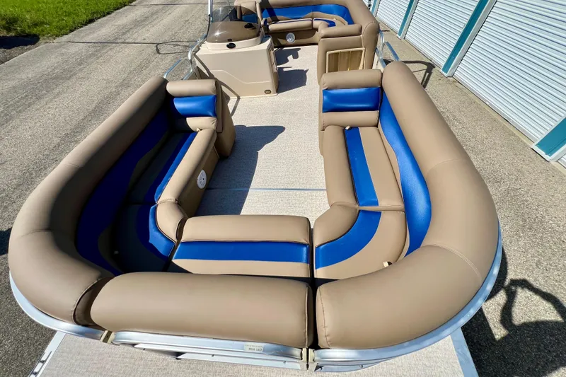 Slide: The Image of 2001 Premier 250 Grand Majestic pontoon boat with tan and blue seating, docked outdoors. - 4