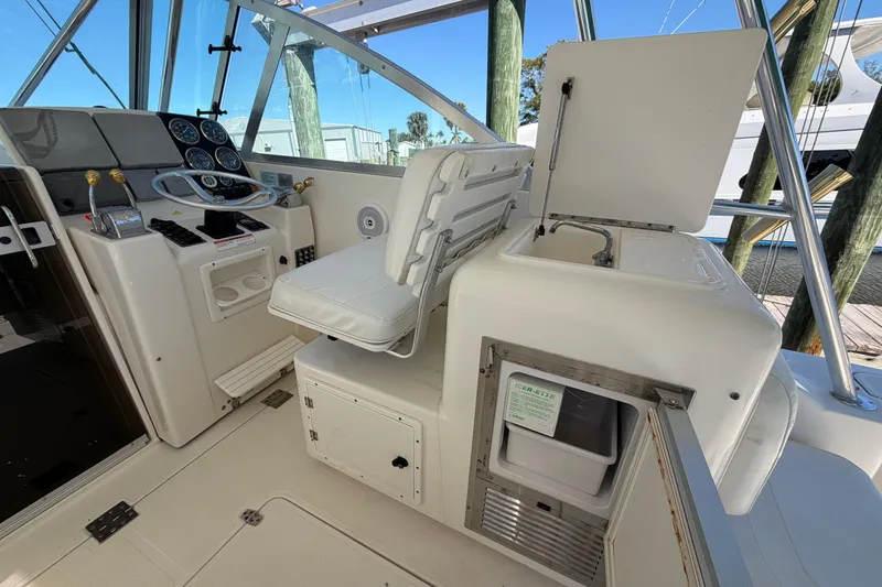 Slide: The Image of 2001 Pursuit 3000 Express boat cockpit with helm, seating, and storage compartments. - 16