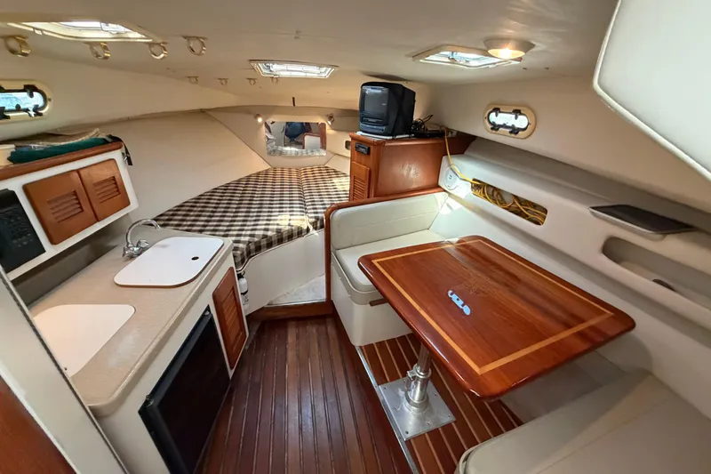 Slide: The Image of 2001 Pursuit 3000 Express cabin interior with kitchenette, bed, and dining area. - 22