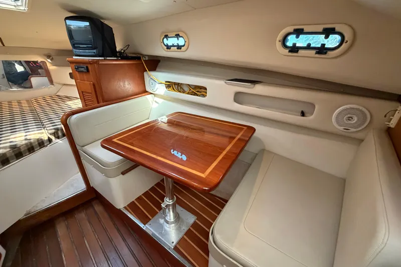 Slide: The Image of 2001 Pursuit 3000 Express cabin interior with dining area and cozy seating. - 23