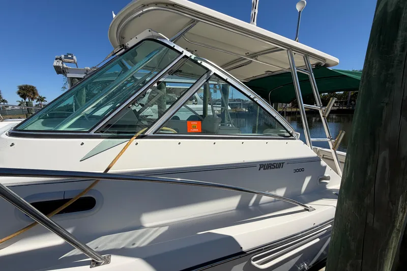 Slide: The Image of 2001 Pursuit 3000 Express boat docked, featuring sleek design and sturdy construction. - 3