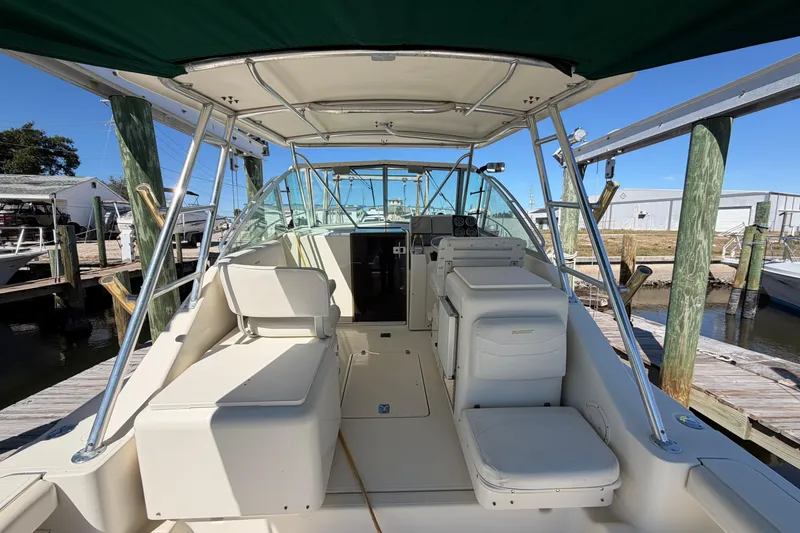 Slide: The Image of 2001 Pursuit 3000 Express boat interior with seating and helm, docked at marina. - 7