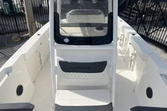 Slide: The Image of 2023 Trophy T24 CC boat interior with seating and console, docked outdoors. - 10