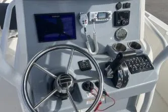 Slide: The Image of 2023 Trophy T24 CC boat dashboard with steering wheel and navigation controls. - 12