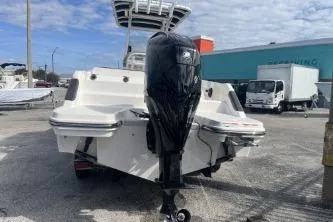 Slide: The Image of 2023 Trophy T24 CC boat with outboard motor, parked outdoors on a sunny day. - 6