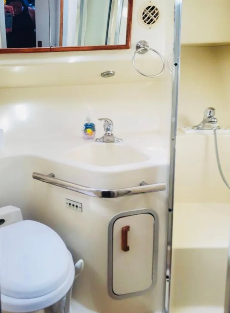 Slide: The Image of 1994 Sea Ray 400 Express Cruiser bathroom with sink, toilet, and shower. - 12