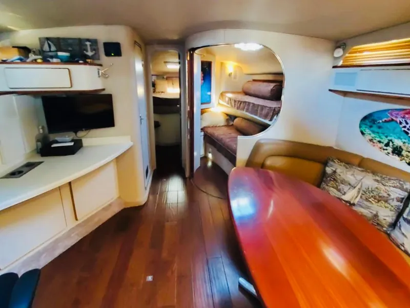 Slide: The Image of Interior of 1994 Sea Ray 400 Express Cruiser with wood flooring and cozy seating area. - 7