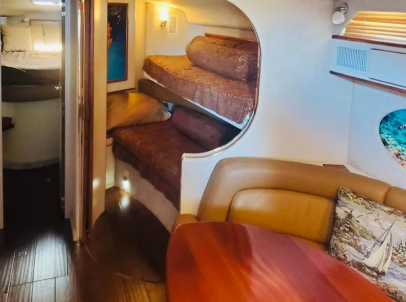 Slide: The Image of Interior of 1994 Sea Ray 400 Express Cruiser with cozy seating and bunk beds. - 8
