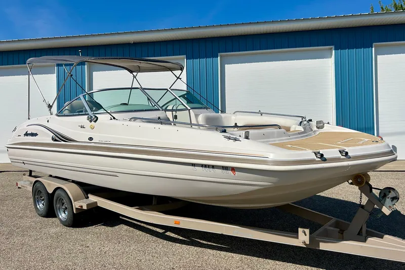 Slide: The Image of 2001 Hurricane SunDeck 237 OB boat on trailer, parked near blue building. - 21