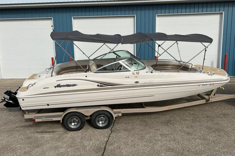 Slide: The Image of 2001 Hurricane SunDeck 237 OB boat on trailer, parked near blue building. - 4