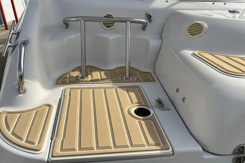 Slide: The Image of 2001 Hurricane SunDeck 237 OB boat interior with tan non-slip flooring and stainless steel railing. - 6