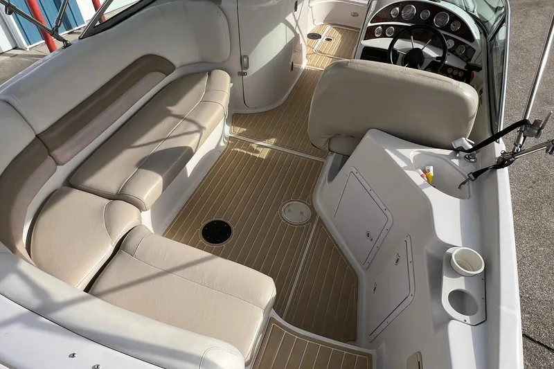 Slide: The Image of 2001 Hurricane SunDeck 237 OB interior with beige seating and steering console. - 7