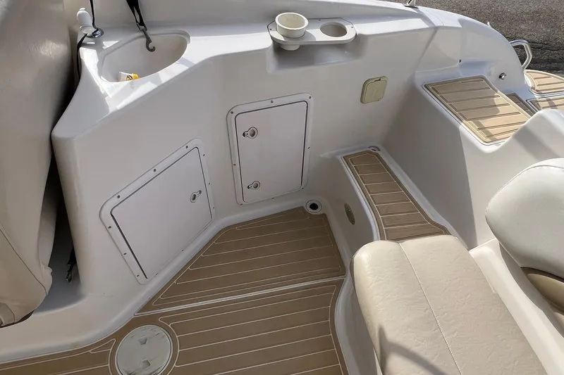 Slide: The Image of 2001 Hurricane SunDeck 237 OB boat interior with seating, storage compartments, and cup holders. - 9
