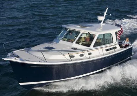 The Image of 2010 Back Cove 37 yacht cruising on calm waters with scenic mountain backdrop. - 0