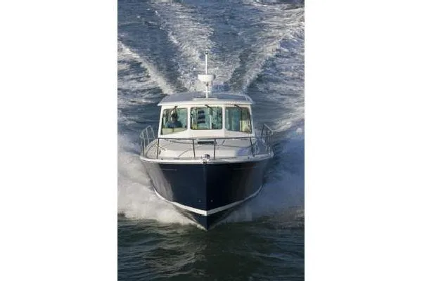 Slide: The Image of 2010 Back Cove 37 yacht cruising on a scenic lake with forested hills. - 2