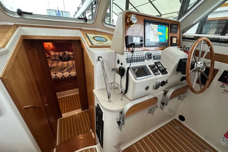 Slide: The Image of 2010 Back Cove 37 yacht interior with striped seating and scenic water view. - 29