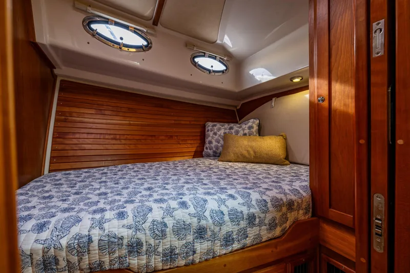 Slide: The Image of Cozy cabin interior of 2010 Back Cove 37 boat with wooden accents and nautical bedding. - 50