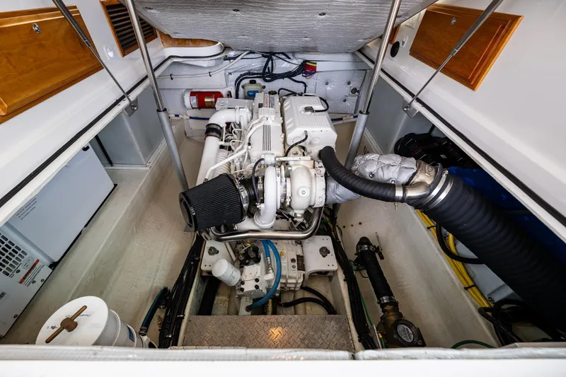 Slide: The Image of Engine compartment of a 2010 Back Cove 37 boat, showcasing detailed mechanical components. - 61