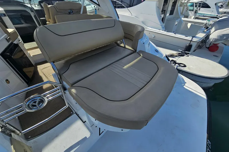 Slide: The Image of 2012 Cruisers Yachts 350 Express with beige seating, docked at marina. - 16
