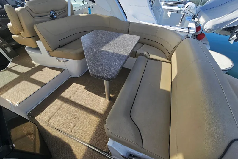Slide: The Image of 2012 Cruisers Yachts 350 Express interior with beige seating and a central table. - 17
