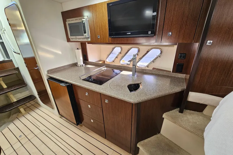 Slide: The Image of 2012 Cruisers Yachts 350 Express interior kitchen with modern appliances and sleek design. - 23