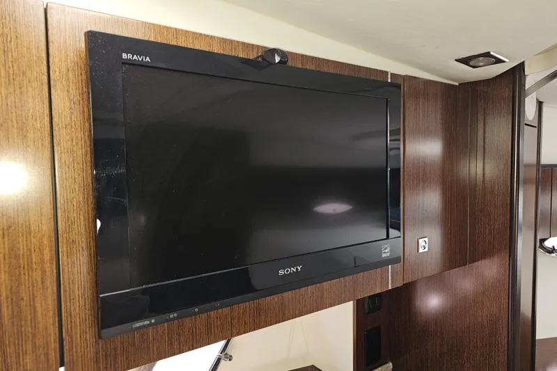 Slide: The Image of Sony Bravia TV mounted on wood paneling inside 2012 Cruisers Yachts 350 Express. - 24