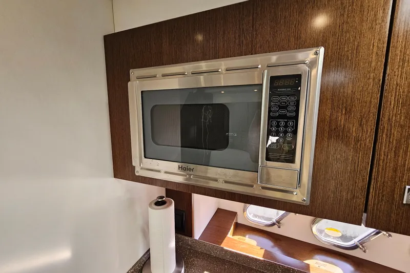 Slide: The Image of Haier microwave in 2012 Cruisers Yachts 350 Express kitchen with wood cabinetry. - 27