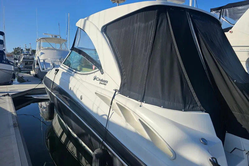 Slide: The Image of 2012 Cruisers Yachts 350 Express docked at marina, featuring sleek design and black canopy. - 6