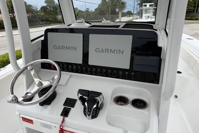 Slide: The Image of 2025 Sea Hunt Ultra 265 SE boat dashboard with dual Garmin displays and steering wheel. - 11